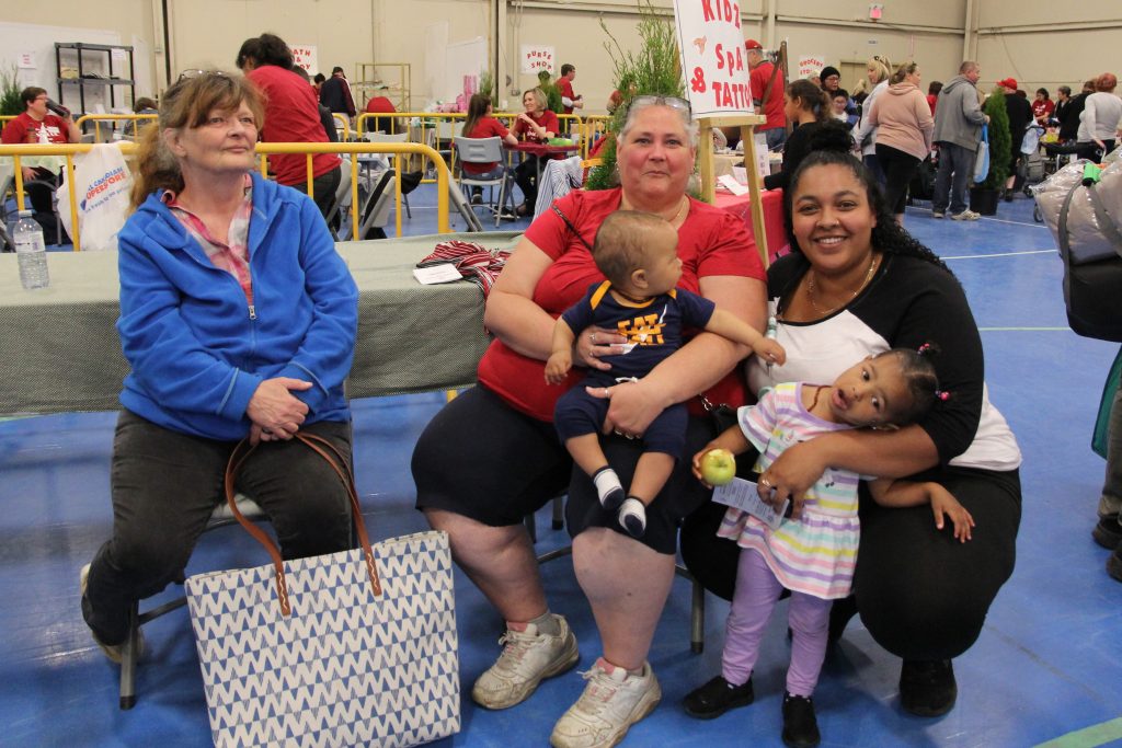 Families and volunteers smiling together at We Believe in Simcoe